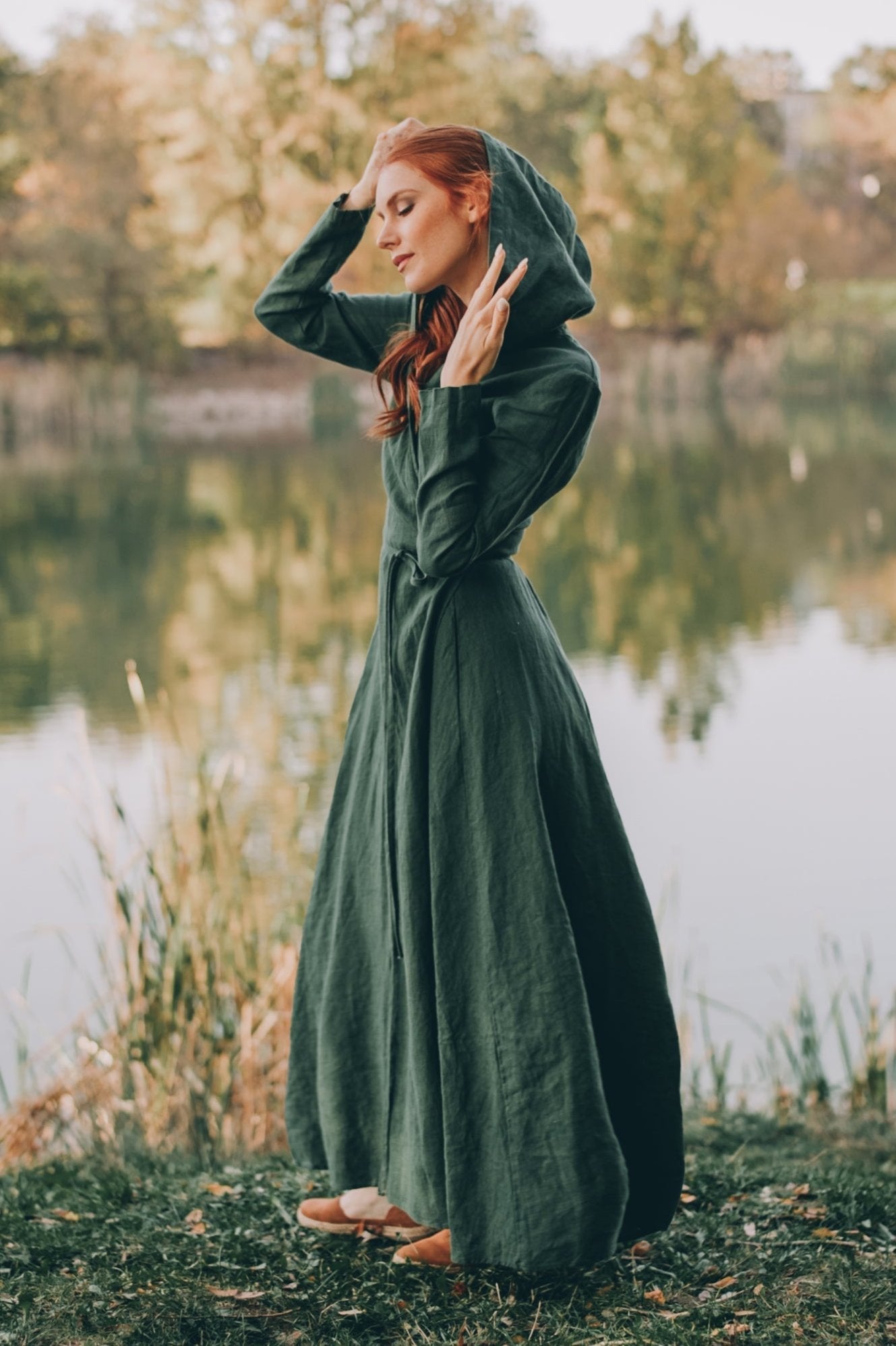 woman wearing green hooded linen maxi dress with tie waist outdoors near lake