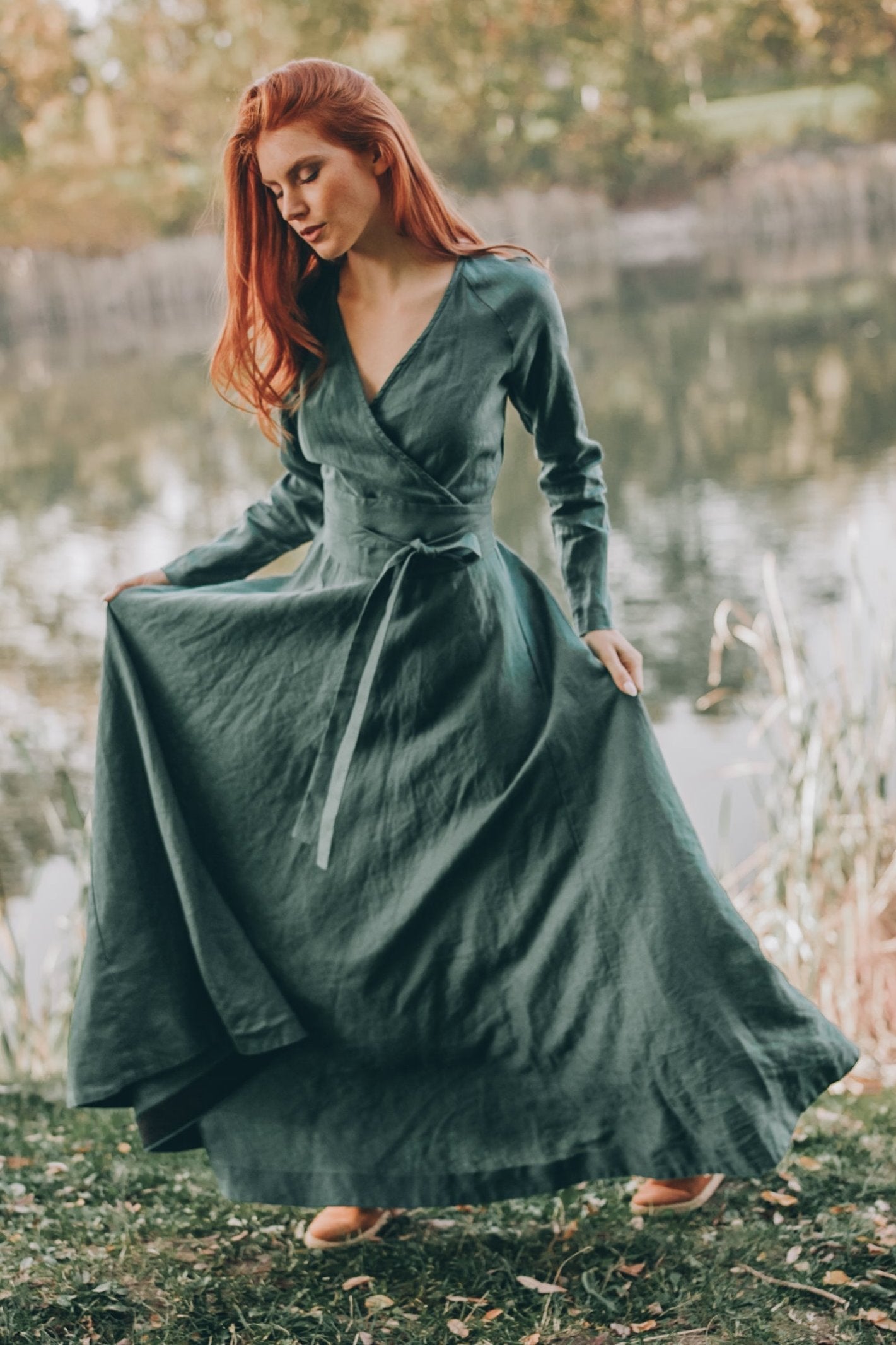 Woman wearing a heavy linen wrap dress with waist belt outdoors by the lake