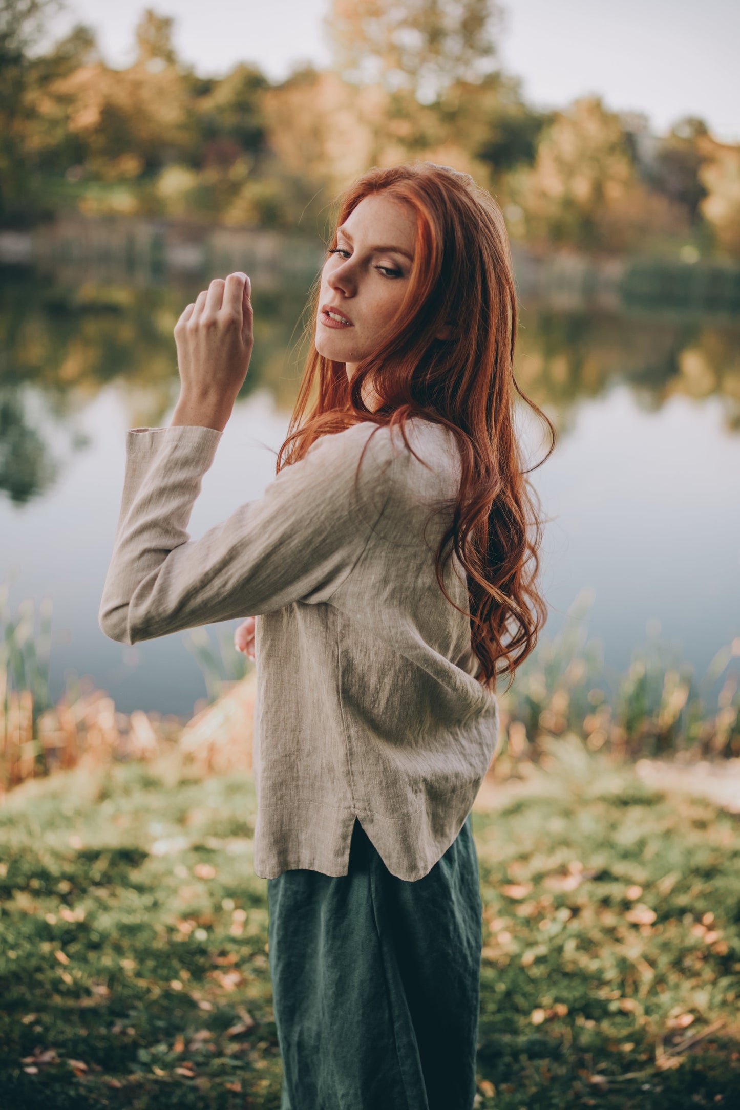 Woman wearing heavyweight linen staple top with three-quarter sleeves by a lake outdoors