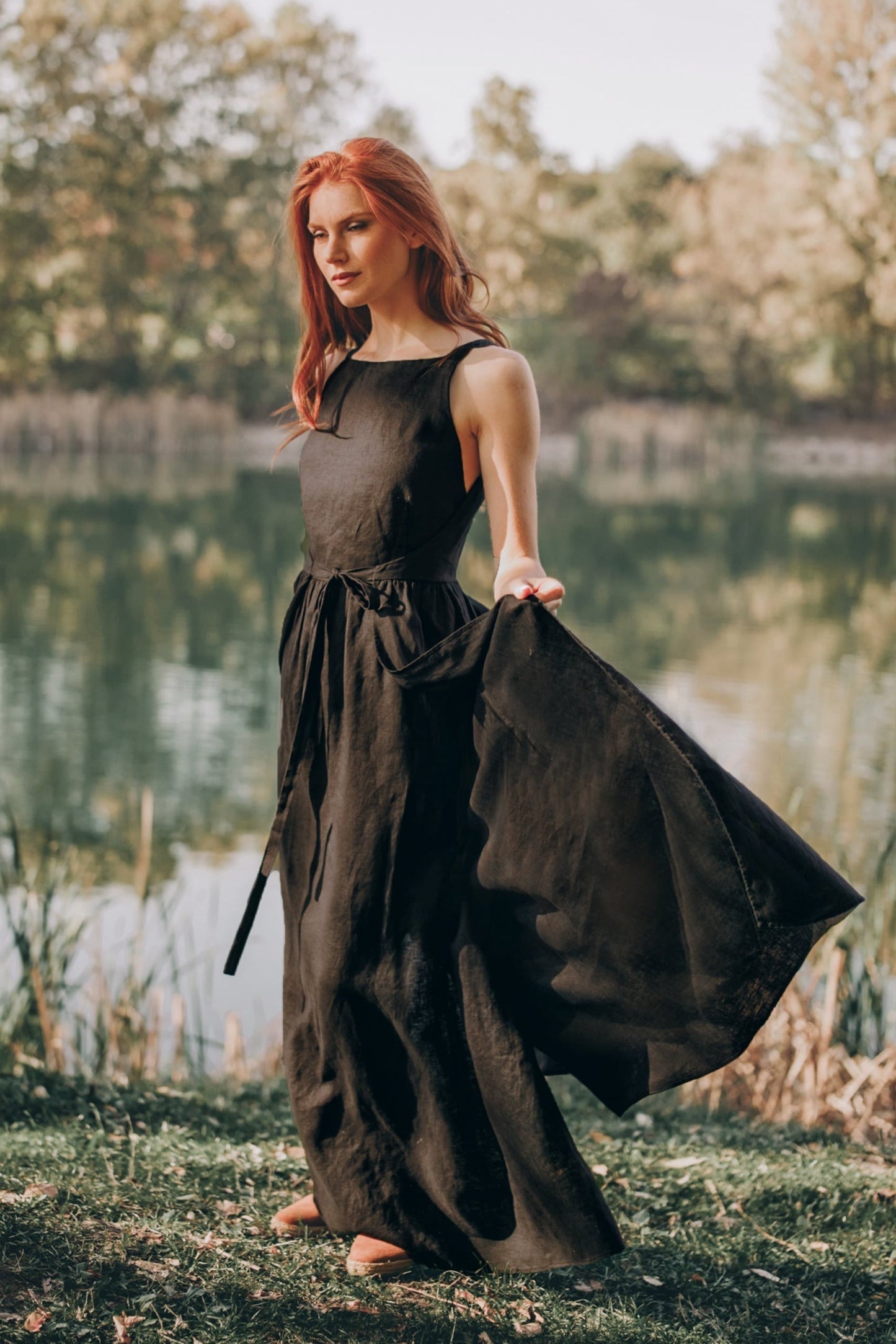 Woman wearing black double wrap linen maxi dress standing outdoors near a lake