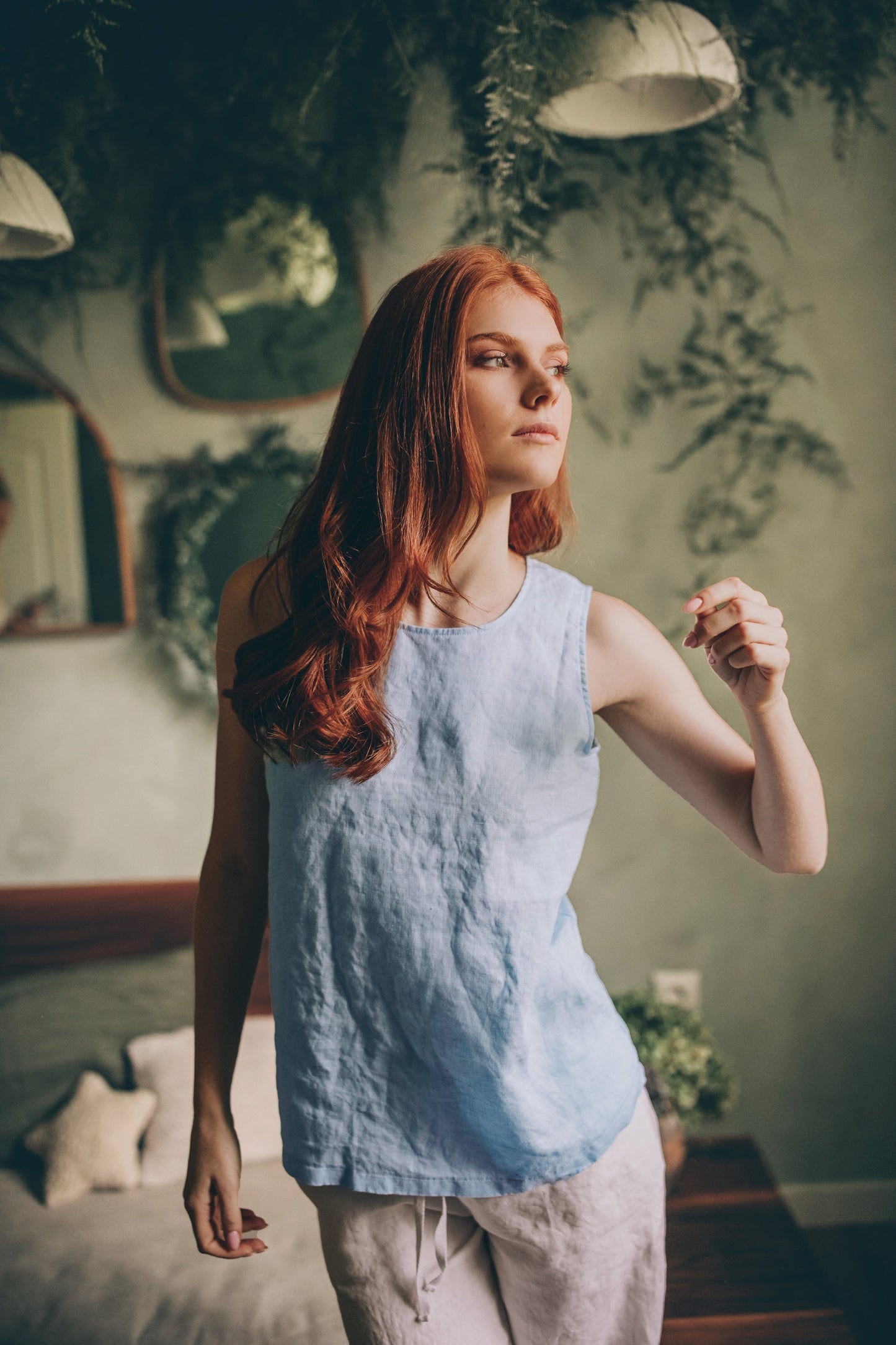 Woman wearing light blue linen sleeveless top in a relaxed bohemian fit indoors