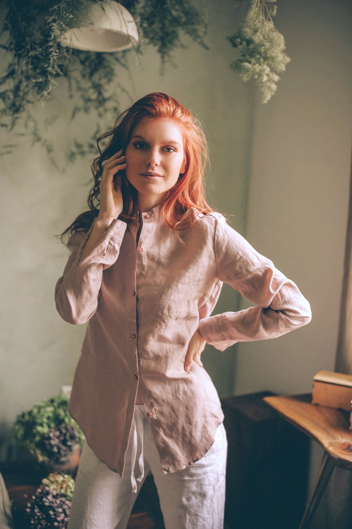 Woman wearing blush classic linen shirt with casual sleeve cuffs indoors