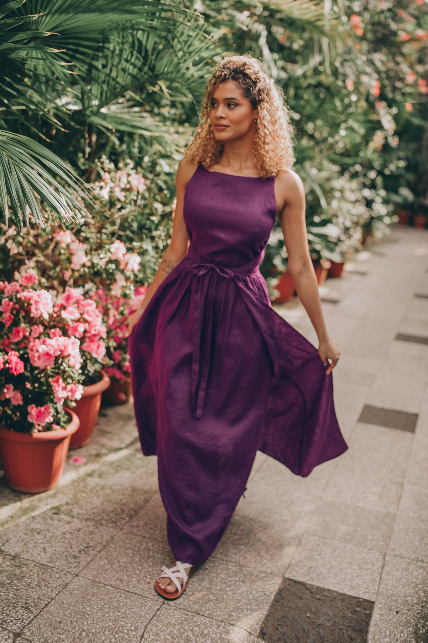 Woman wearing a double wrap linen maxi dress in a garden setting.