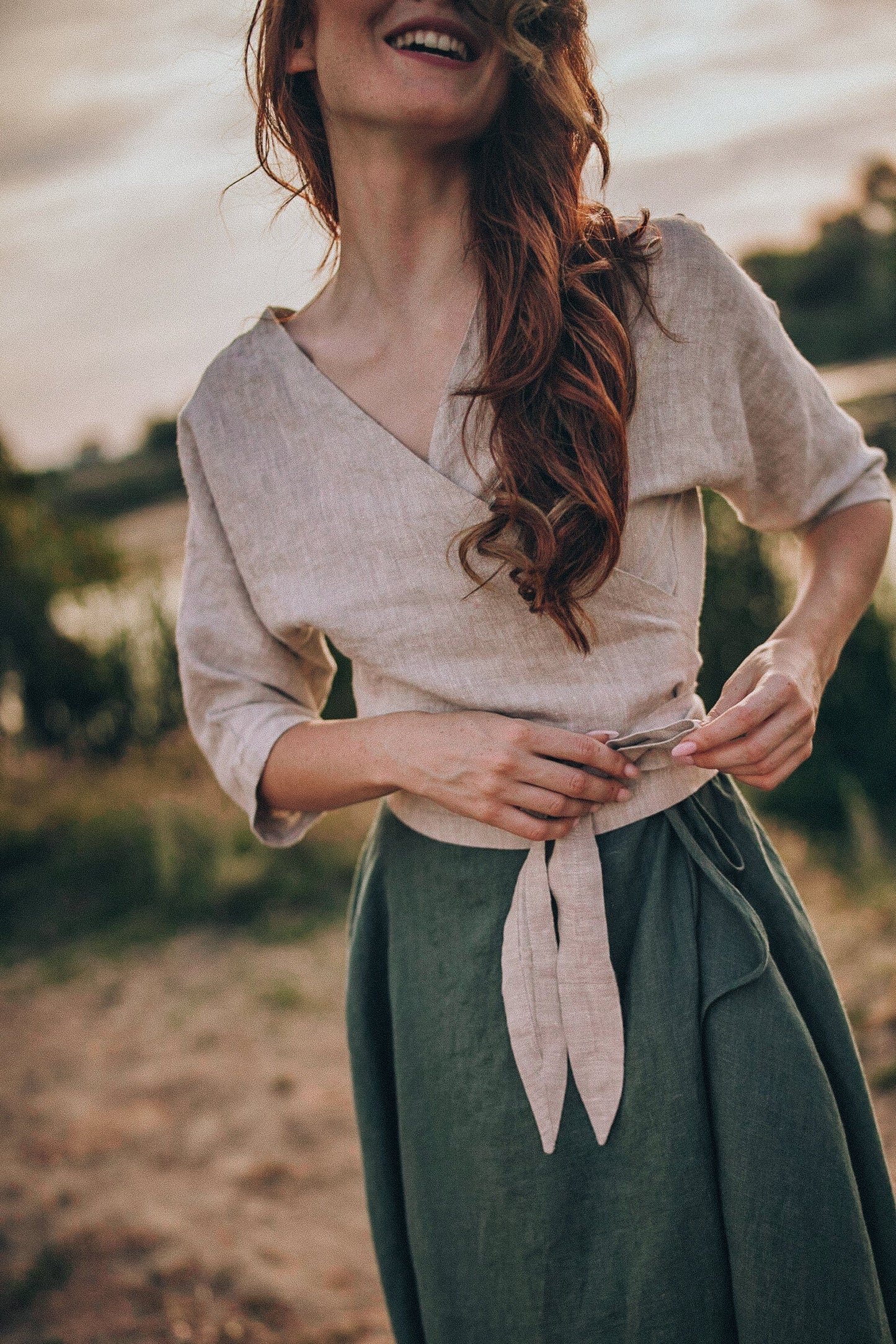 woman wearing minimalist linen wrap top with elbow sleeves and tie closure outdoors