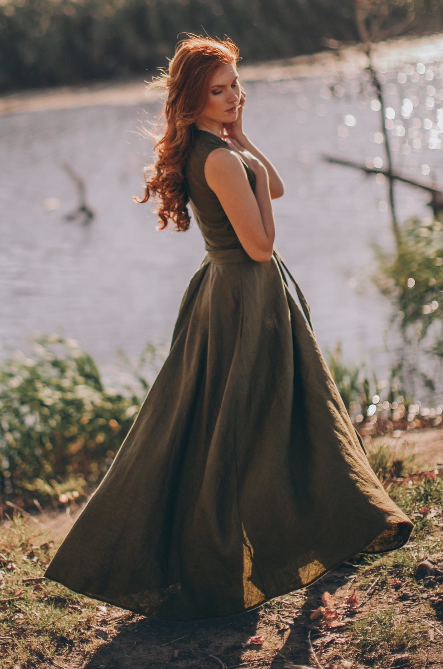 Woman wearing sleeveless linen maxi dress with tie waist outdoors near water