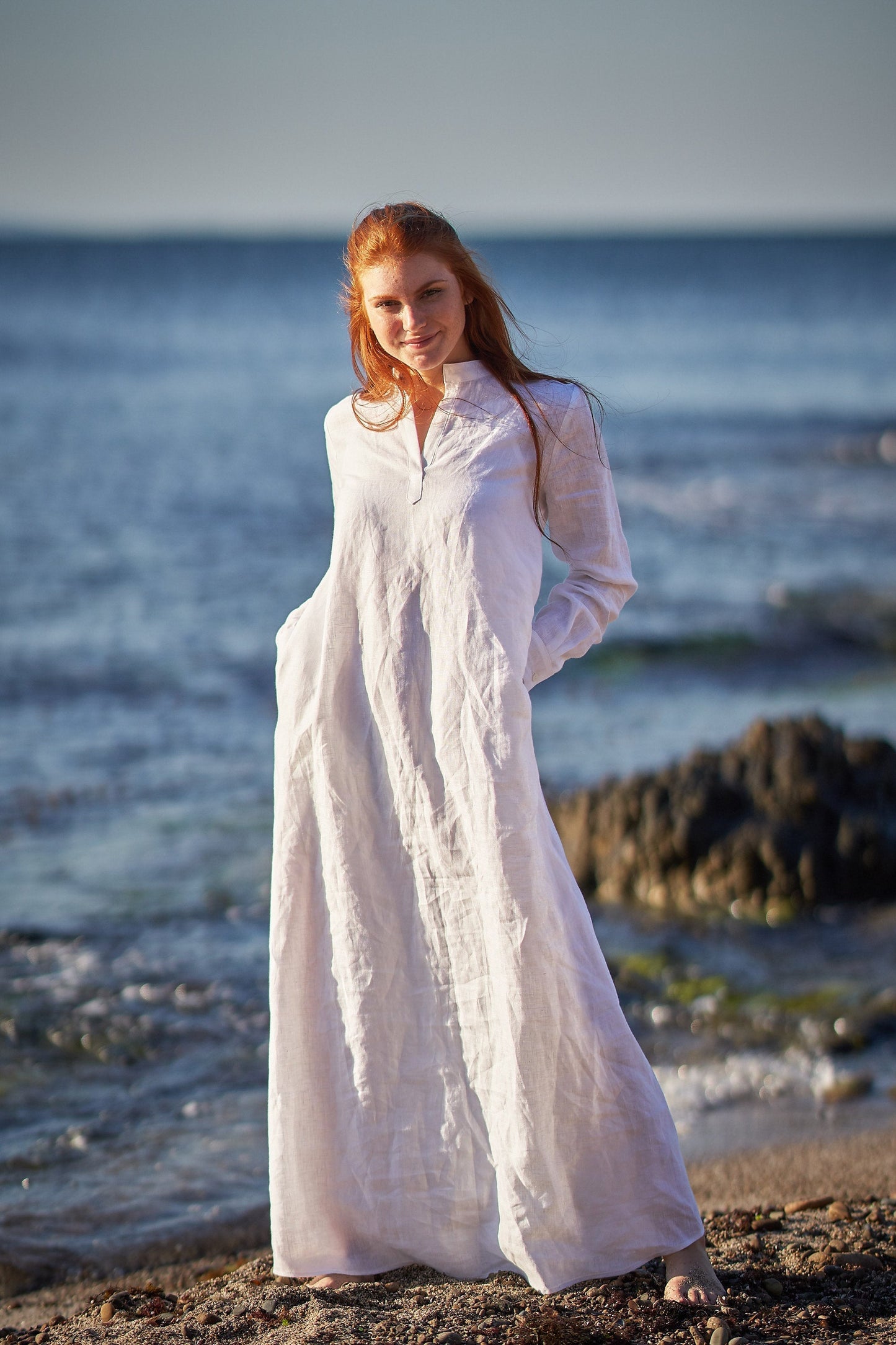 Woman wearing a full sleeve linen kaftan dress standing by the seaside