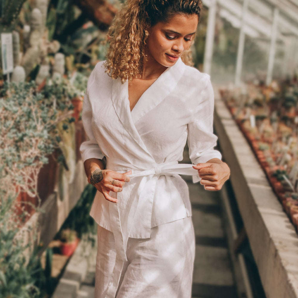 Linen wrap top with shawl neckline and tie belt, worn by woman in garden setting.
