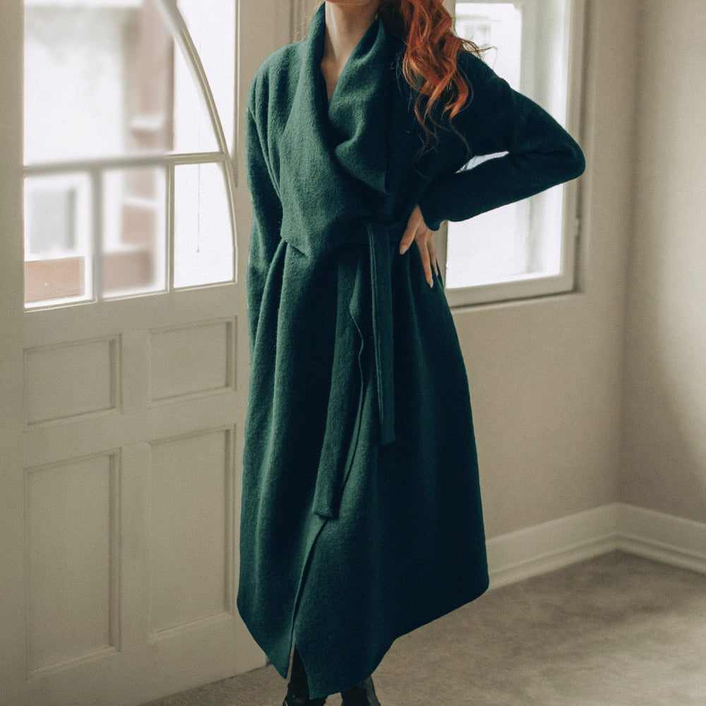 Woman wearing draped wool cardigan coat with belted wrap and waterfall front indoors
