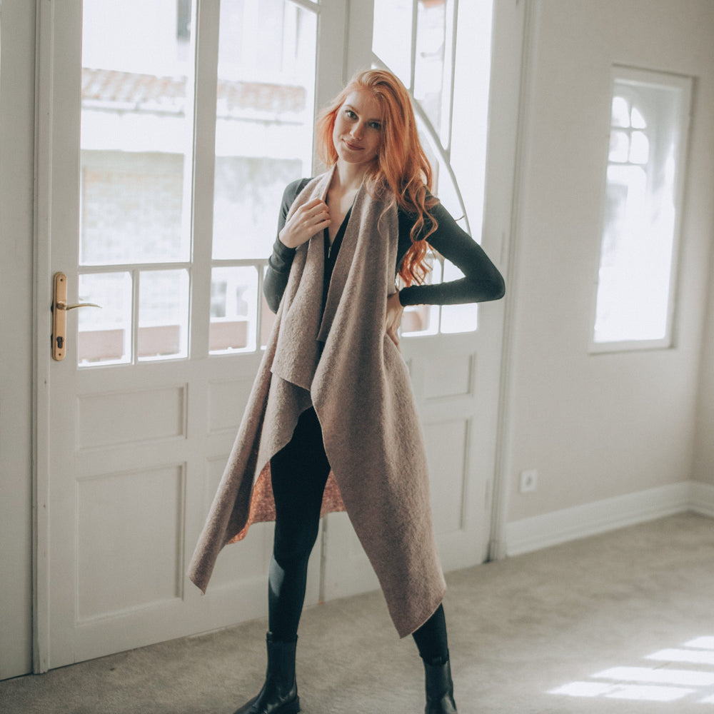Woman standing in a room with large windows wearing a Asymmetric Wool Vest