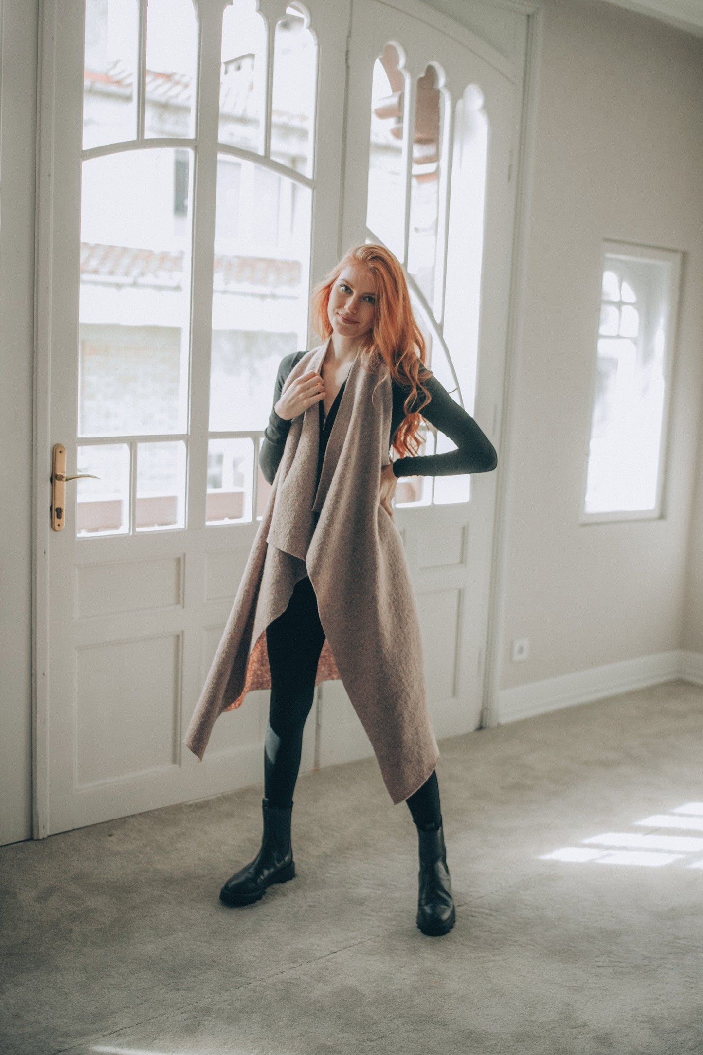 Woman standing in a room with large windows wearing a Asymmetric Wool Vest