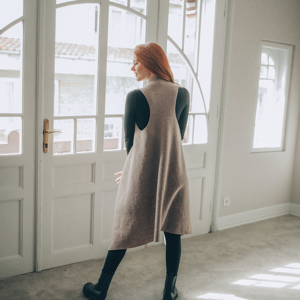 
                      
                        Woman standing in a room with large windows wearing a Asymmetric Wool Vest
                      
                    