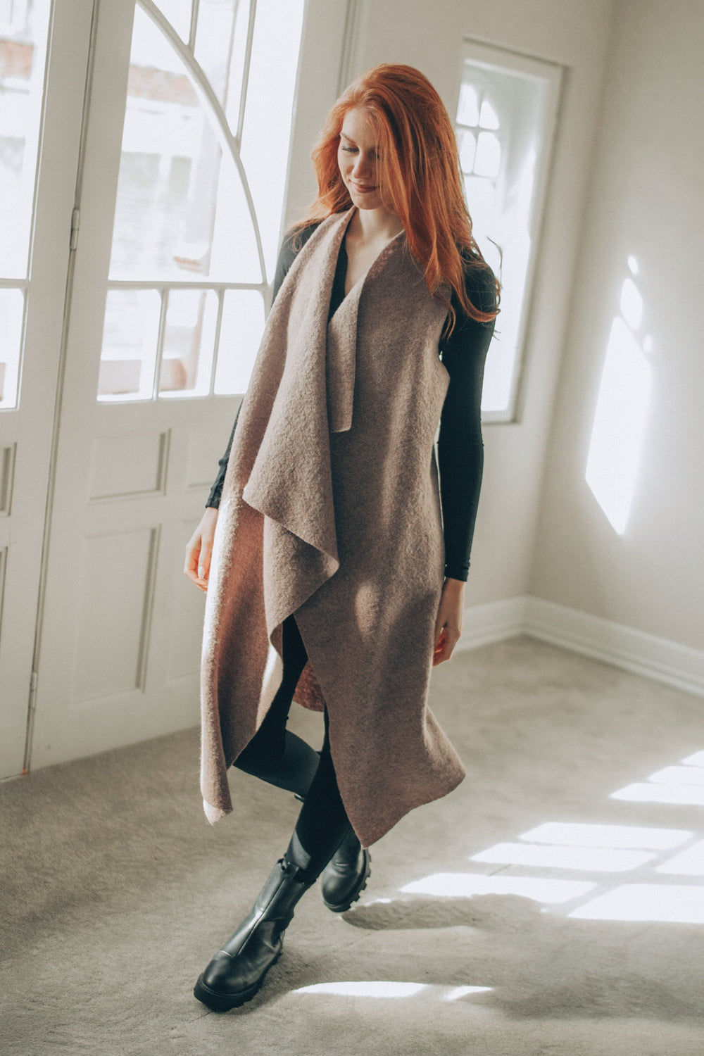 Woman wearing asymmetric wool vest with modern draped silhouette indoors