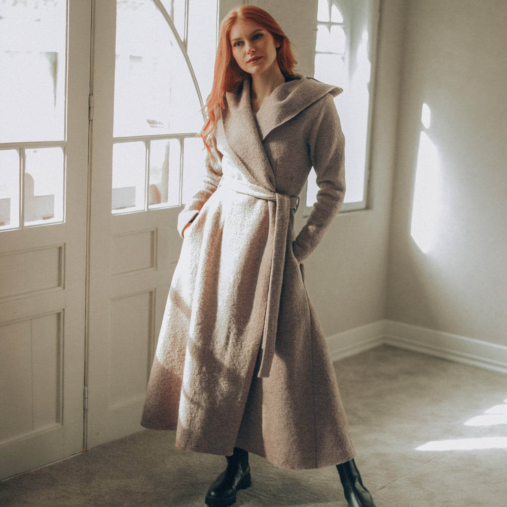 
                      
                        Woman in a Maxi Wool Hooded Cardigan Coat standing in a room with large windows.
                      
                    