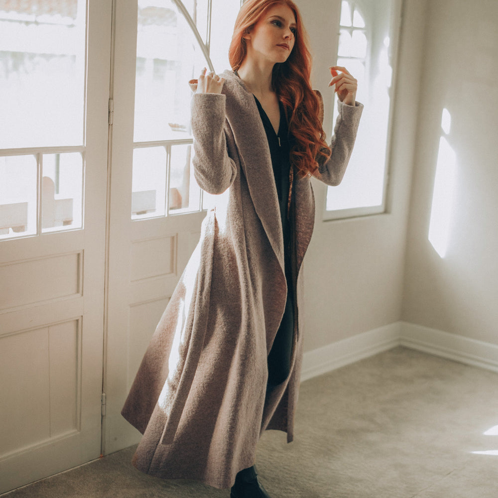 
                      
                        Woman in a Maxi Wool Hooded Cardigan Coat standing in a room with large windows.
                      
                    