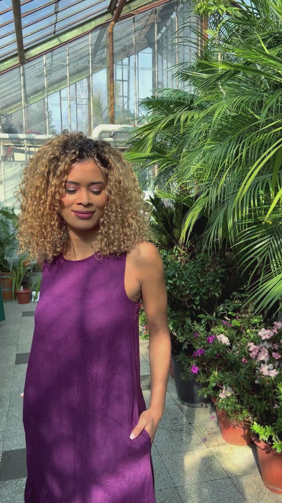 Video of a sleeveless linen midi dress with a relaxed fit, flared hem, and side pockets, showing the silhouette and movement of the design.