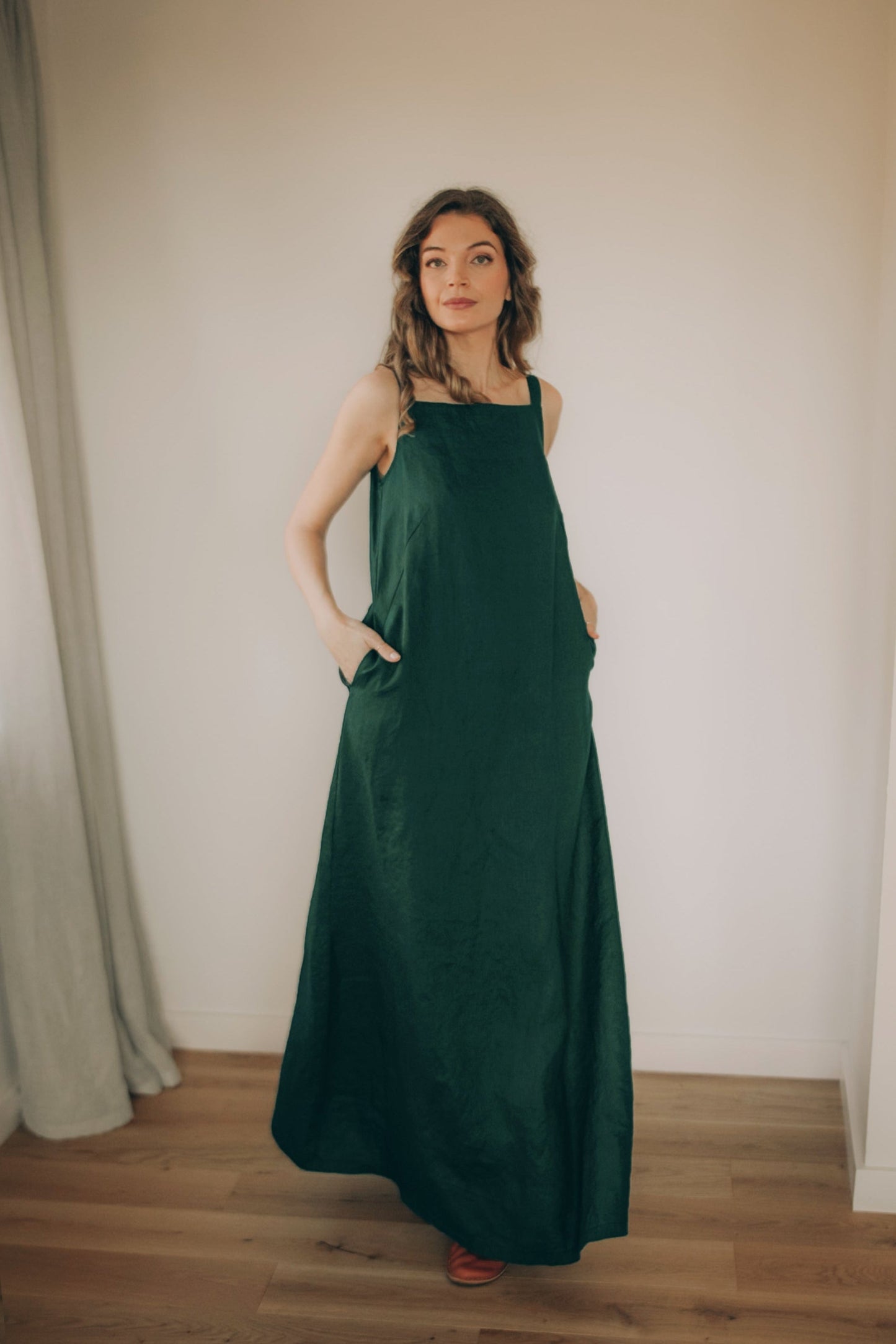 Minimalist A-line linen maxi dress with shoulder straps and side pockets for summer style