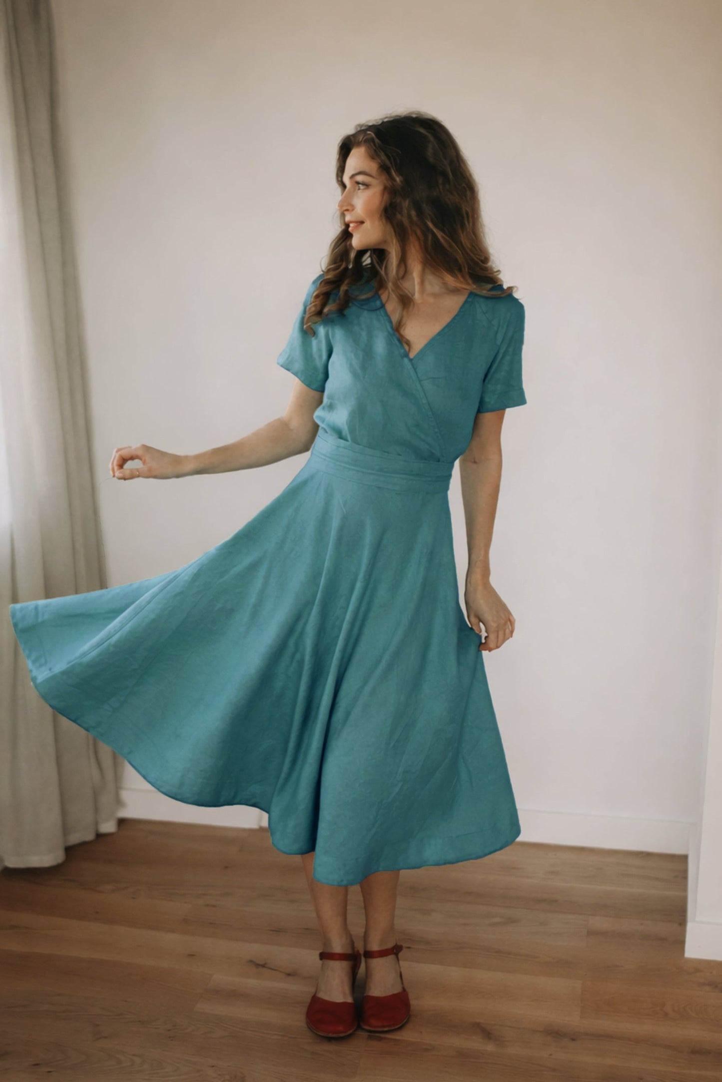Woman wearing beige linen midi dress with obi belt and side pockets