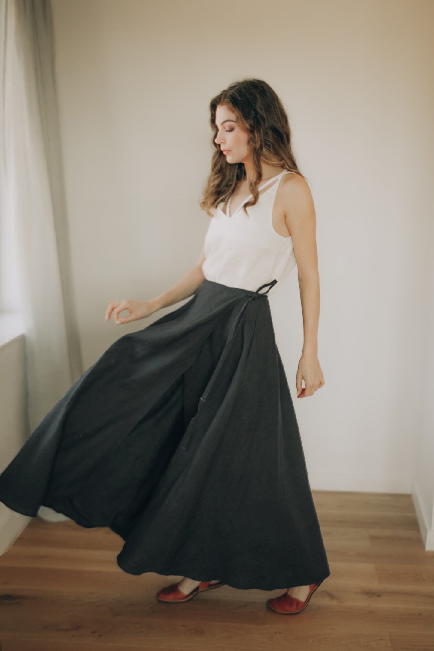 Model wearing heavyweight linen wrap skirt with side pockets and ankle-length design